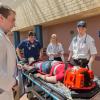 During a three-day set of emergency simulations that involved 320 Penn College students, Timothy F. Schwartzer (in hat), an emergency medical services student from Bensalem, explains to students in other health sciences majors how paramedics would begin treatment for a patient – played by a volunteer actor – who had fallen from a second-floor balcony.