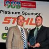 Penn College alumnus Jeremy L. Thorne holds his Young Entrepreneur of the Year Award, presented by PLANET President Jim McCutcheon. (Photo by Philippe Nobile Photography)