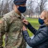 Ana Coste pins gold bars onto the uniform of her son, Andrew Placencia, of Reading, during his commissioning as an Army second lieutenant in a Dec. 12 ceremony at Pennsylvania College of Technology.