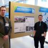 Penn College students Christopher G. Master (left), of Cranberry, and Dustin C. Bailey, of Petersburg, stand in front of the poster for their Habitat for Humanity project, which was among the top finalists at the second annual “Race to Zero Student Design Competition” held recently in Colorado.