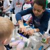 During a previous Science Festival at Penn College, a Williamsport Area High School student uses a black light and a glowing gel to help another student learn about germs and hand-washing.