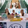 Callie A. Sobolewski (left), nursing; Samar Alquraish (center), nursing; and Angelyvette Santana, radiography, point a nursing student to Student Health Care Workers Week goodies.