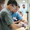 Plastics and polymer engineering technology major Noah L. Martin (third from left, in blue shirt), of South Williamsport, works closely with participants in the recent Thin-Gauge/Roll-Fed Thermoforming Workshop at Penn College.