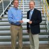 Brian M. Fuhrman, left, major account manager for Waste Management Inc., delivers a donation to Robb Dietrich, executive director of the Penn College Foundation. 