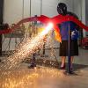 Pennsylvania College of Technology President Davie Jane Gilmour deftly wields a plasma cutter to sever a metal ribbon during a dedication ceremony for a greatly expanded welding facility at the college.